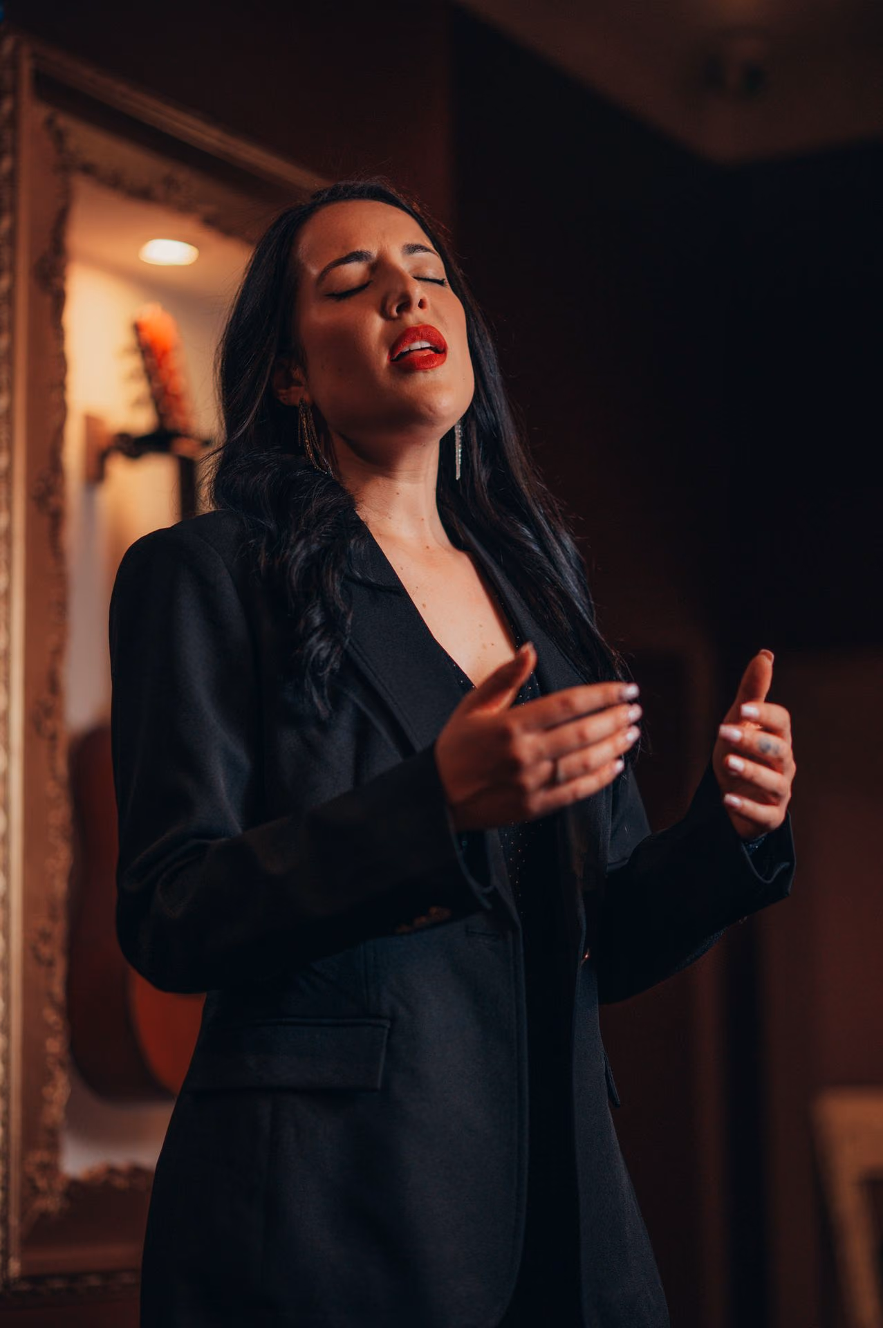 En la sala de la Baixa, en Lisboa, una cantante de americana negra canta Fado con los ojos cerrados y las manos abiertas