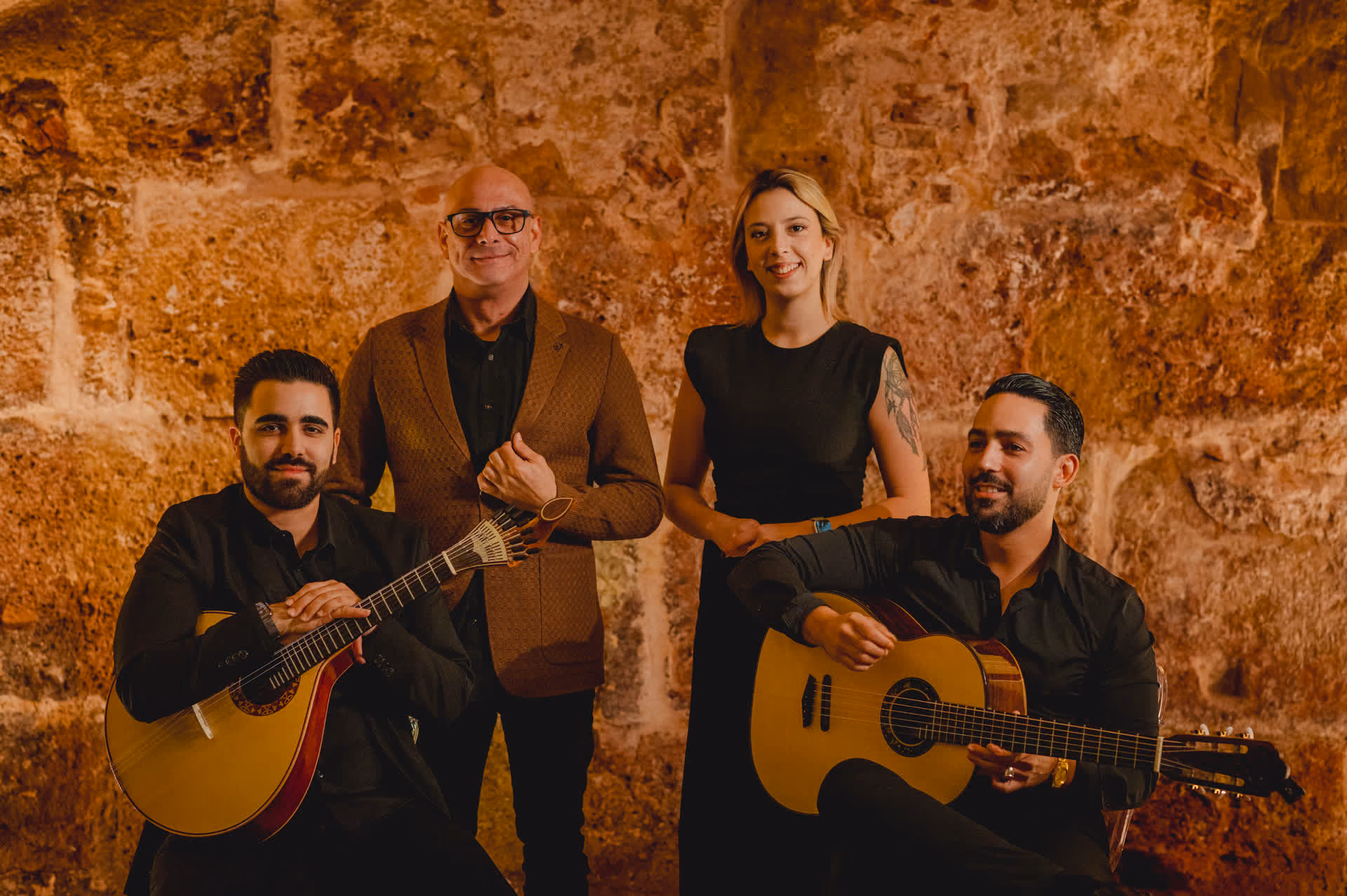 Retrato de grupo ante la piedra antigua: los cuatro músicos de nuestra sala de Fado de la Sé, en Lisboa, dos de ellos con guitarra